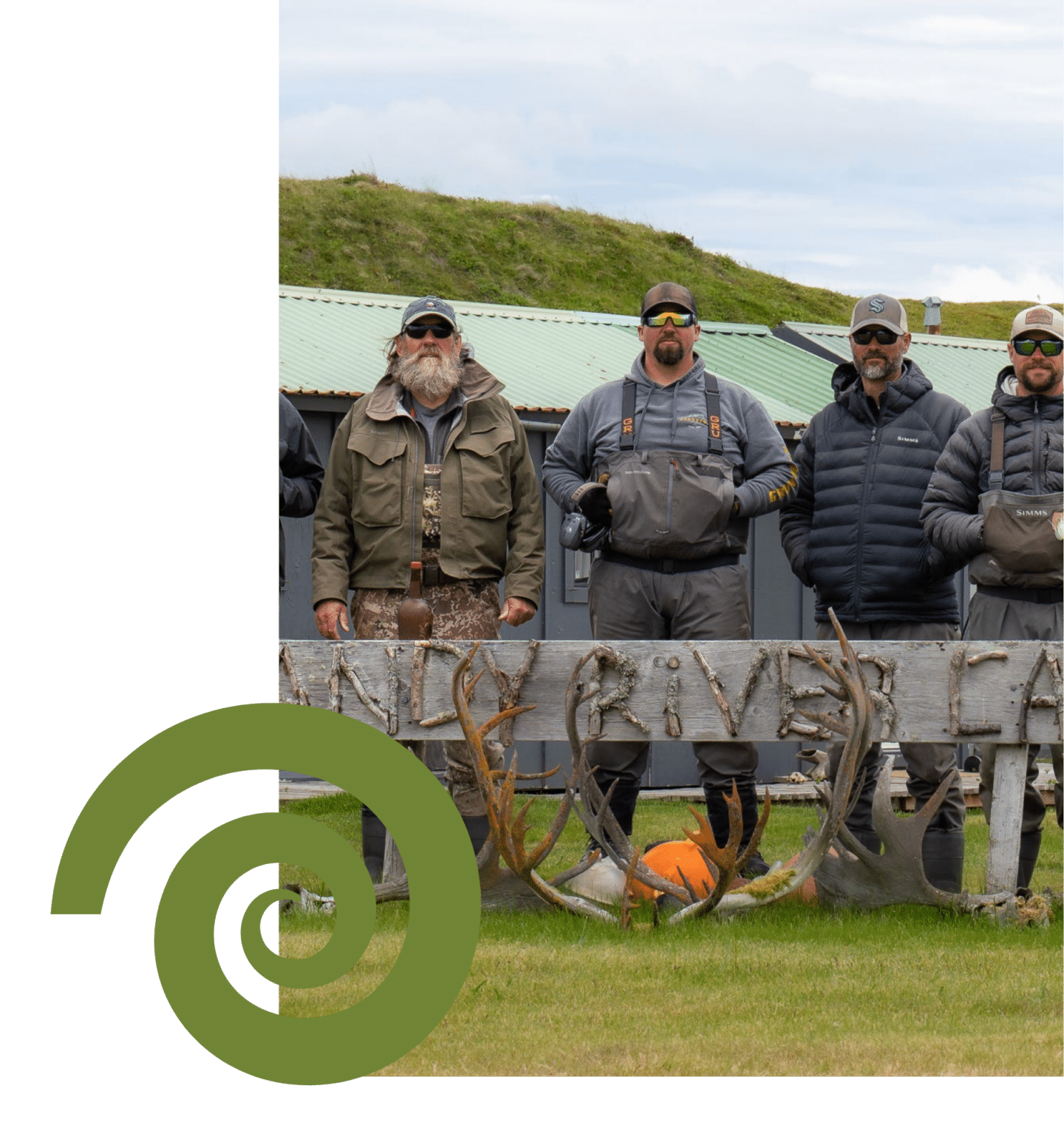 Group of Alaskan fishing guides standing by Sandy River Camp sign
